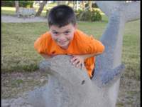 Benjamin riding a stone dolphin